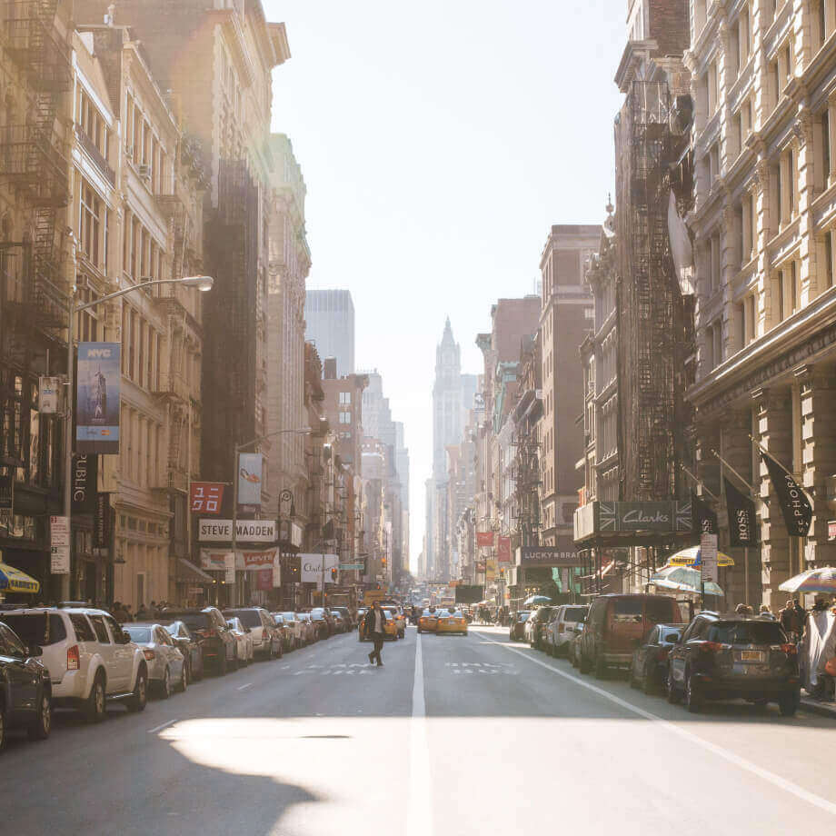 street with cars and one person crossing across the road